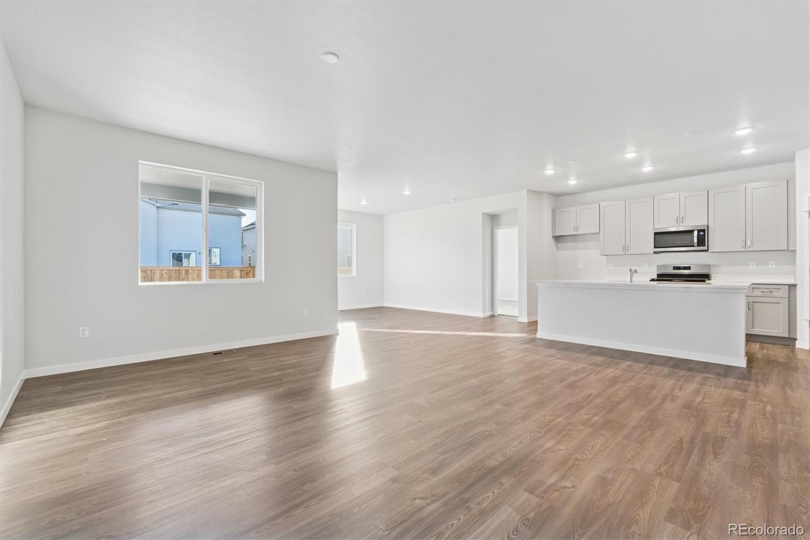 1446 Farmstead Street Brighton, CO 80601 - Photo 8 of 26 a view of kitchen with wooden floor and window