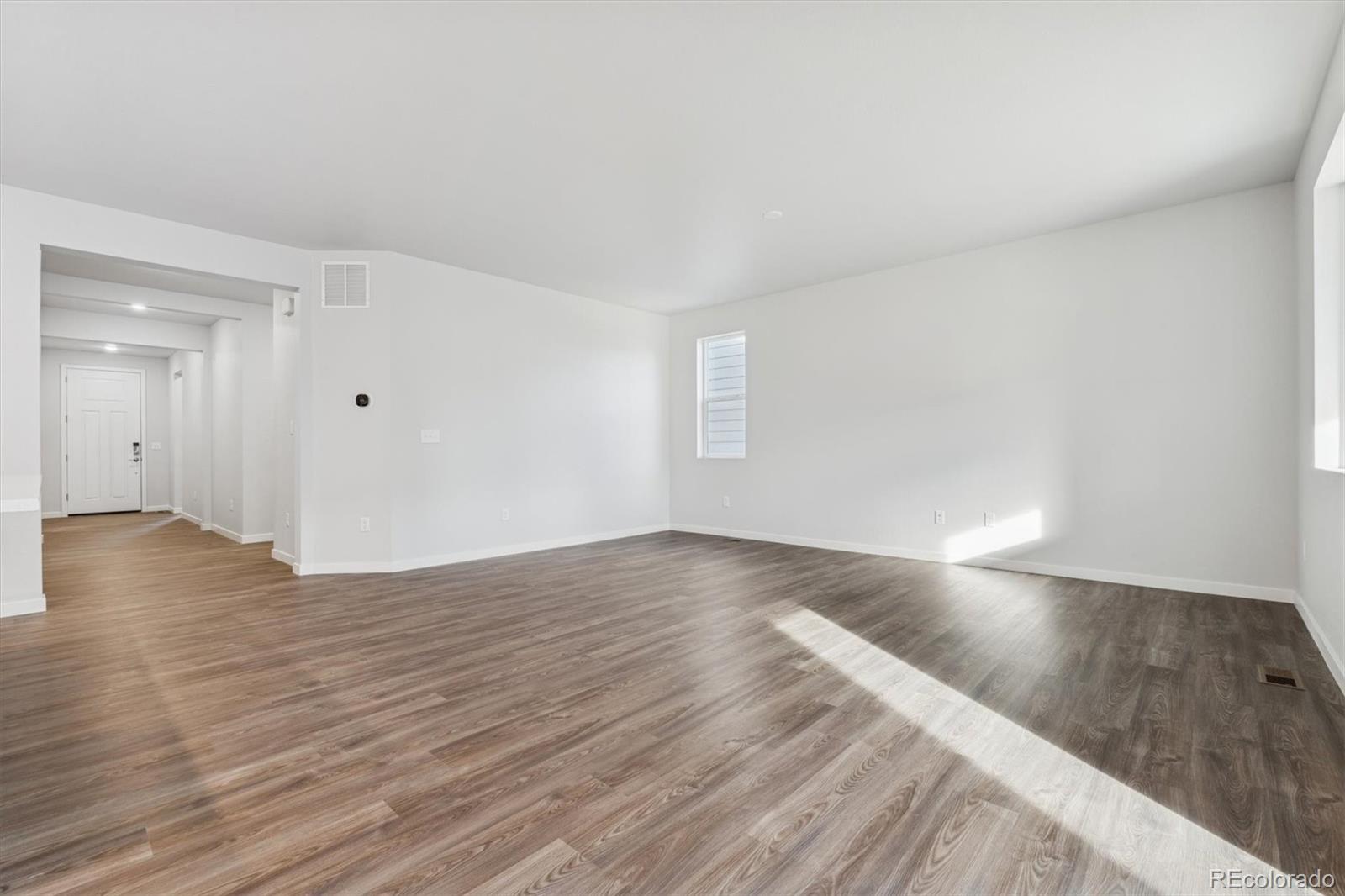 1446 Farmstead Street Brighton, CO 80601 - Photo 9 of 26 a view of an empty room and wooden floor