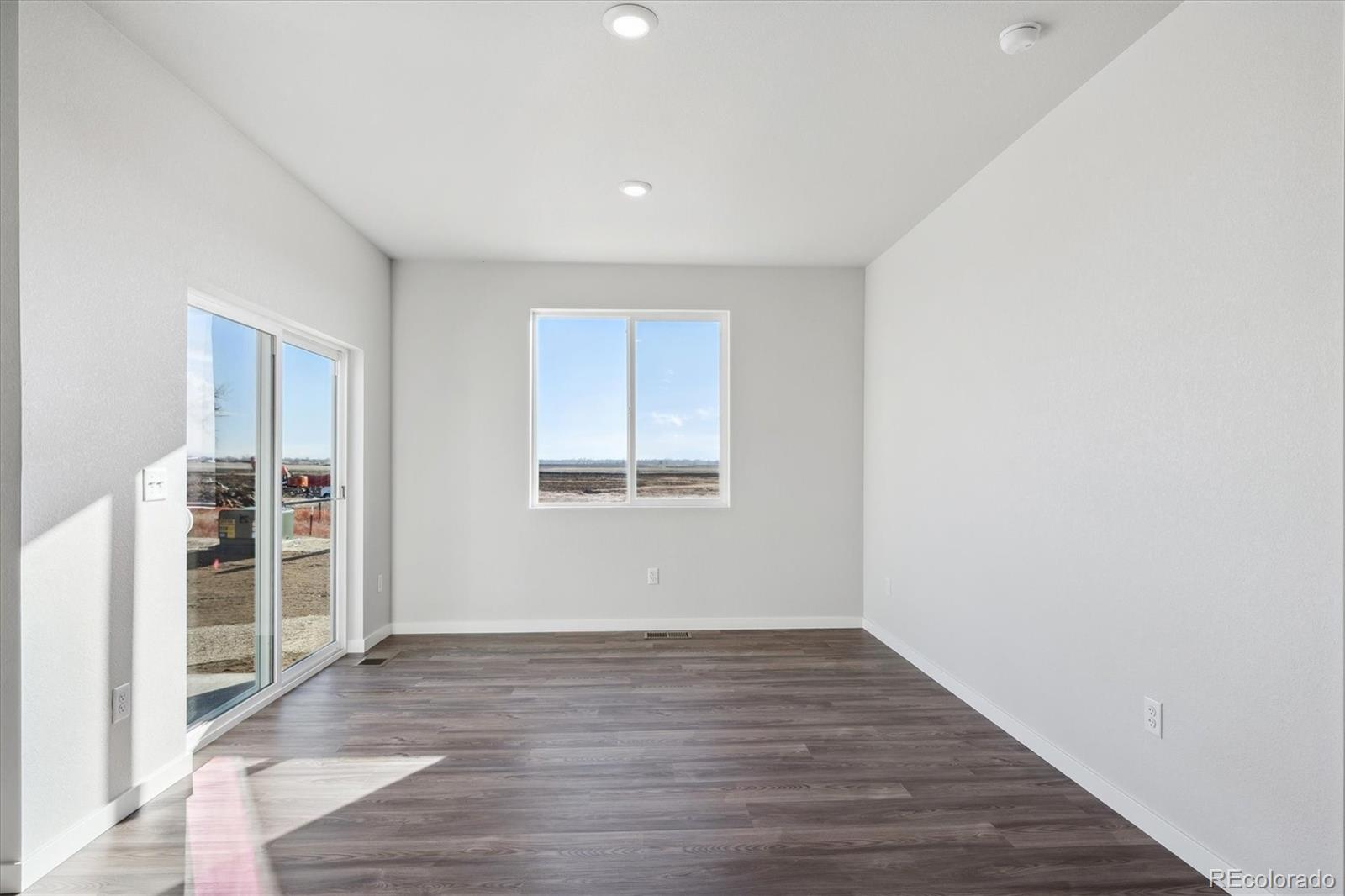 1446 Farmstead Street Brighton, CO 80601 - Photo 10 of 24 a view of wooden floor and windows in a room