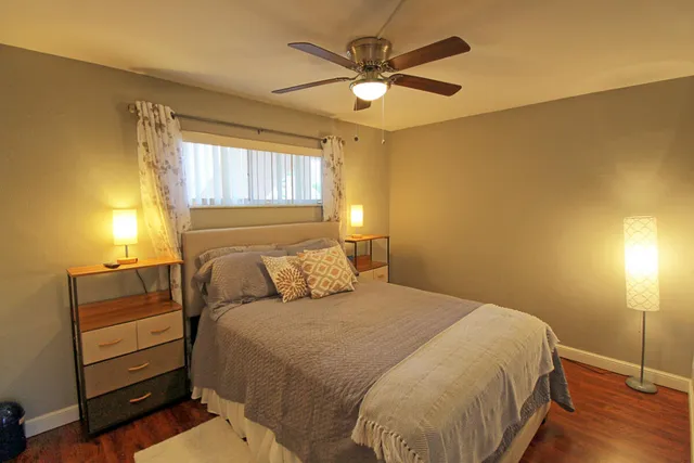 a bedroom with a bed chandelier and a window