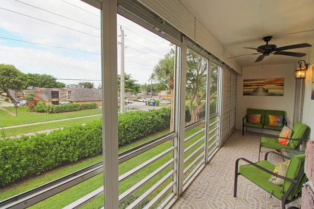 a view of a porch with furniture and a yard