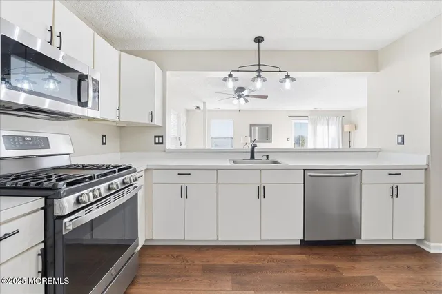 a kitchen with stainless steel appliances granite countertop a stove sink and cabinets
