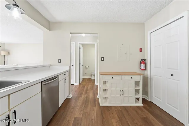 wooden floor with white cabinets and sink