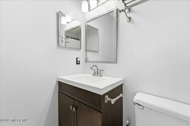 a bathroom with a sink vanity and a toilet