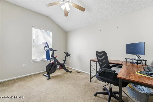 a view of a workspace with furniture and a window