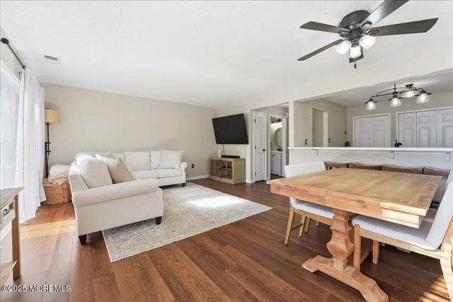 a living room with furniture a flat screen tv and kitchen view