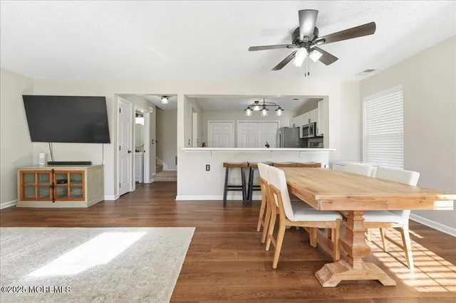 a living room with furniture a flat screen tv and kitchen view