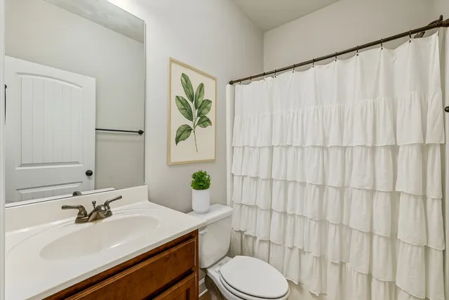 a bathroom with a sink vanity mirror and toilet
