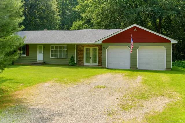 a front view of a house with yard and trees