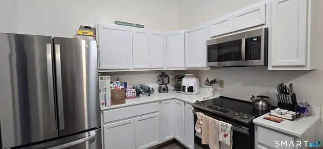 a kitchen with stainless steel appliances granite countertop a refrigerator and a stove top oven