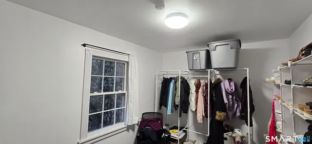 a view of walk in closet with clothes and shoes