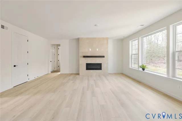 a view of empty room with a fireplace and windows