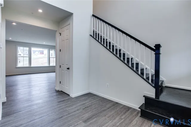 a view of a livingroom with wooden floor and staircase