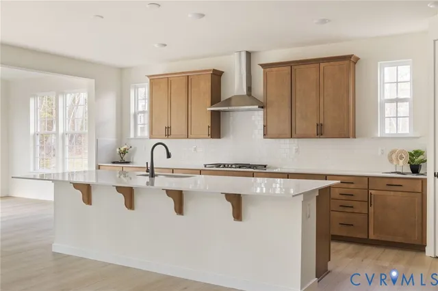 a kitchen with stainless steel appliances granite countertop a stove a sink and white cabinets