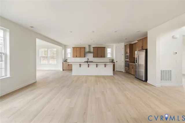 a large white kitchen with a refrigerator a stove top oven a sink and dishwasher