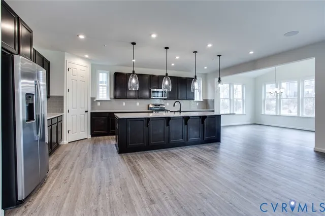 a large kitchen with stainless steel appliances granite countertop a large counter top a sink stainless steel appliances and cabinets