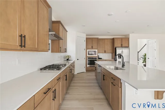 a kitchen with stainless steel appliances granite countertop a sink stove and refrigerator