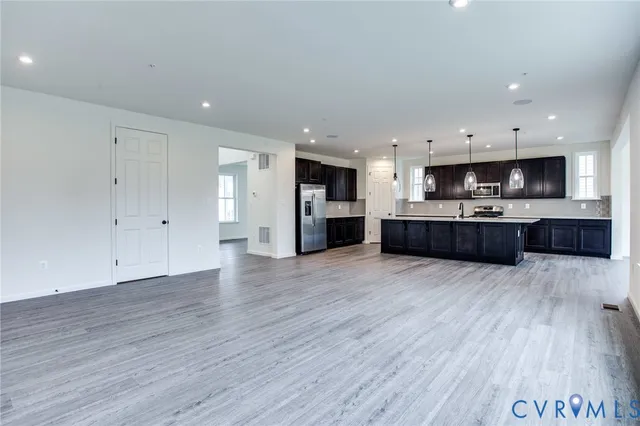 a large kitchen with cabinets wooden floor and stainless steel appliances