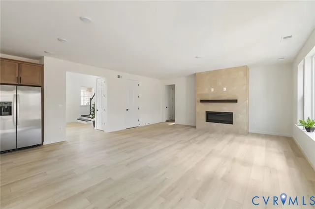 an empty room with fireplace and windows