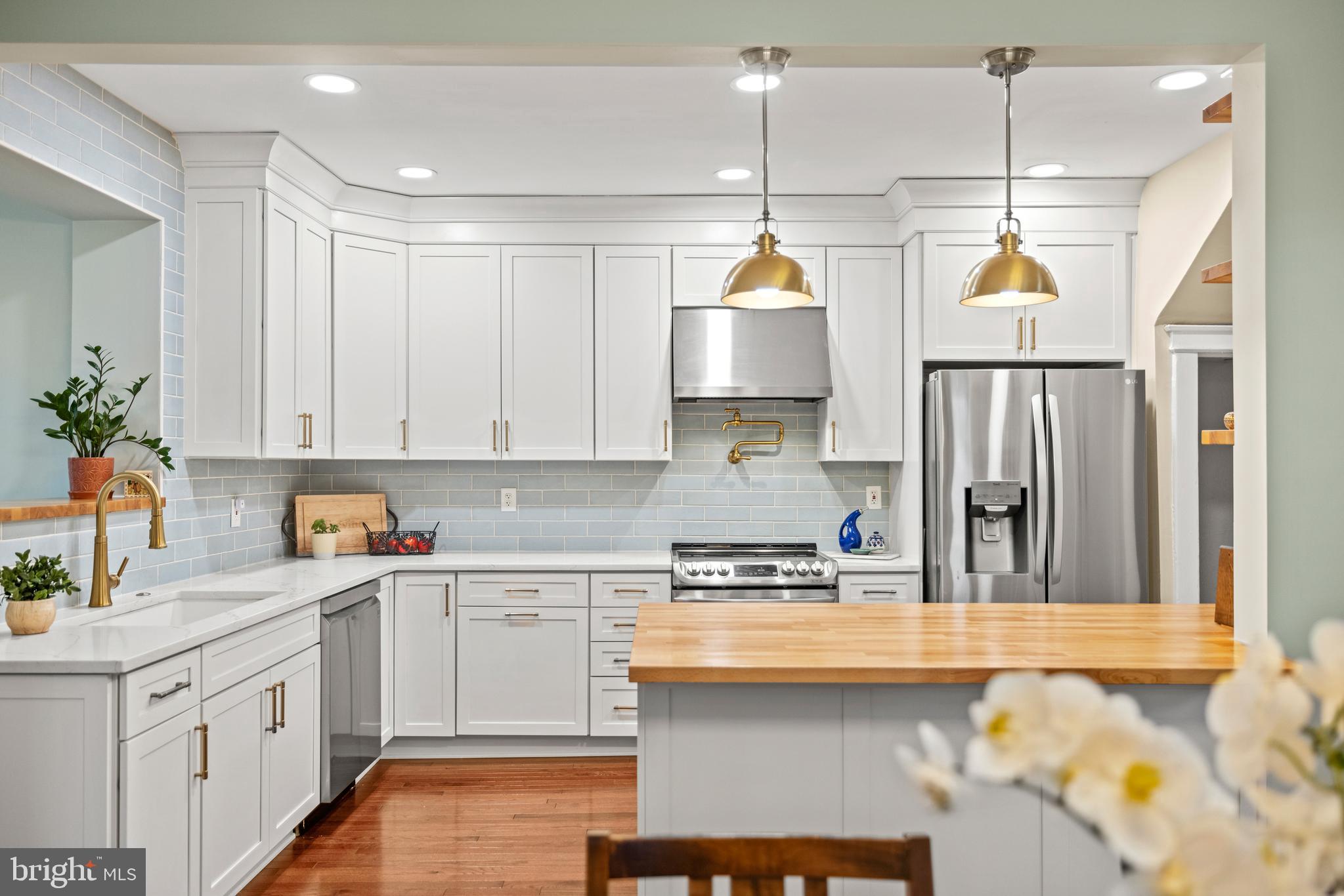 a kitchen with kitchen island granite countertop a sink a stove a oven a counter space and cabinets