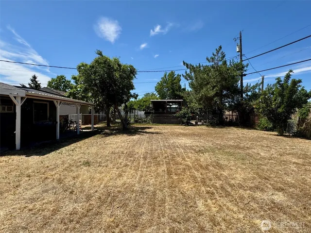 a view of a house with a yard and potted plants