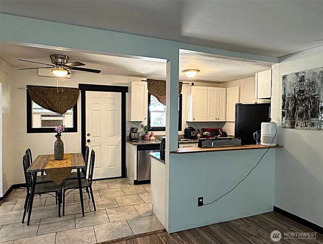 a kitchen with stainless steel appliances kitchen island granite countertop a table and chairs in it