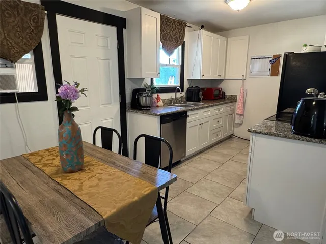 a kitchen with a table chairs and refrigerator