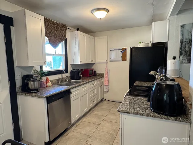 a kitchen with granite countertop a sink stainless steel appliances and cabinets