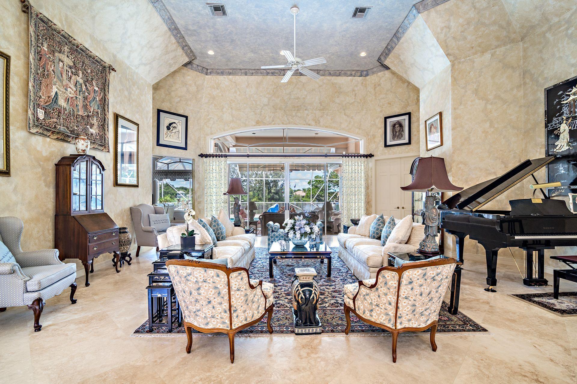 16757 Port Royal Circle Jupiter, FL 33477 - Photo 11 of 65 a living room with patio furniture and a chandelier