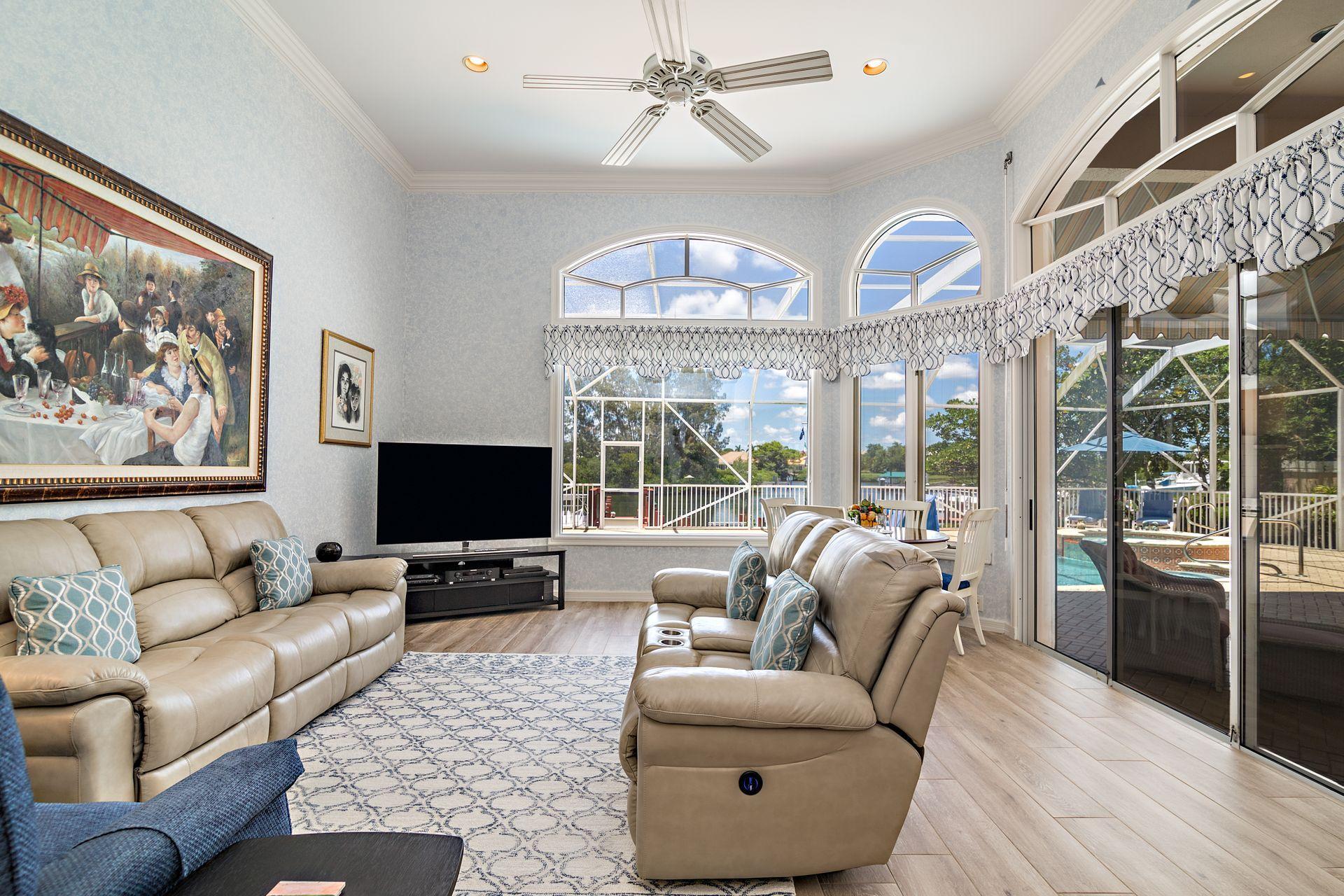 16757 Port Royal Circle Jupiter, FL 33477 - Photo 15 of 65 a living room with furniture a large window and a flat screen tv