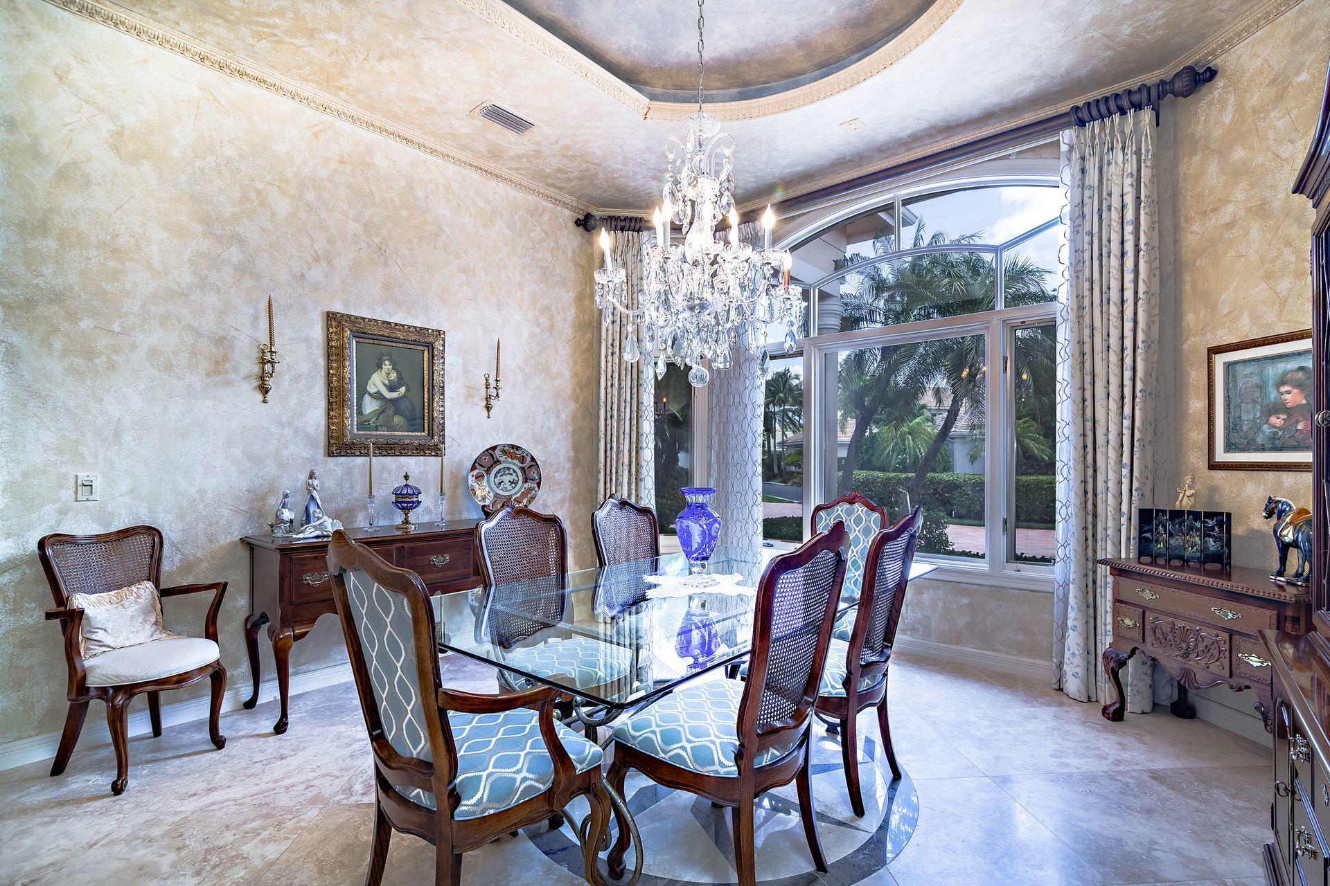 16757 Port Royal Circle Jupiter, FL 33477 - Photo 21 of 65 a dining room with furniture a chandelier and wooden floor