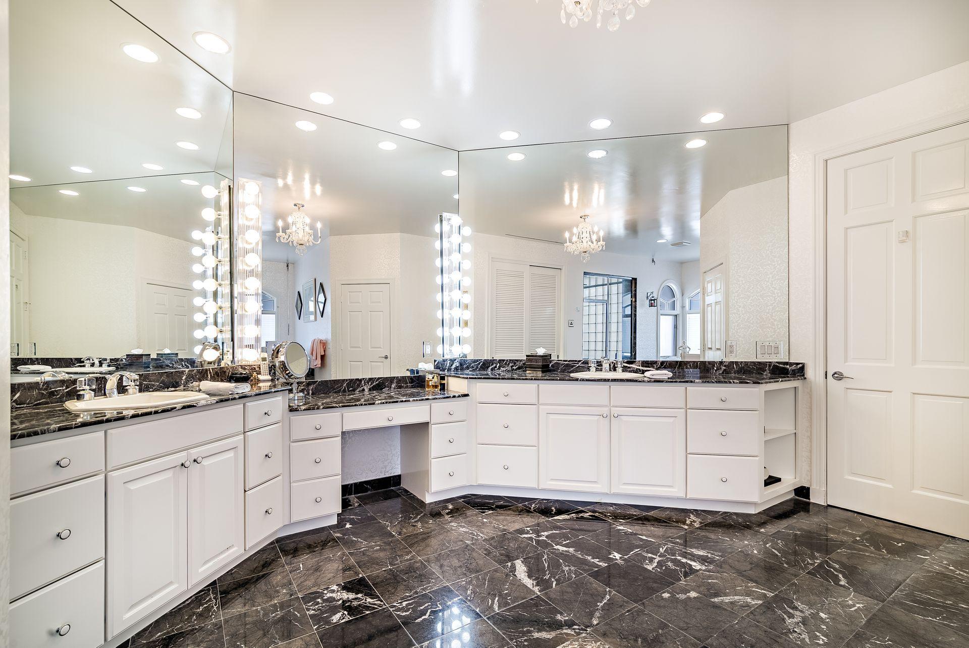 16757 Port Royal Circle Jupiter, FL 33477 - Photo 25 of 65 a large white kitchen with granite countertop a stove a sink and white cabinets