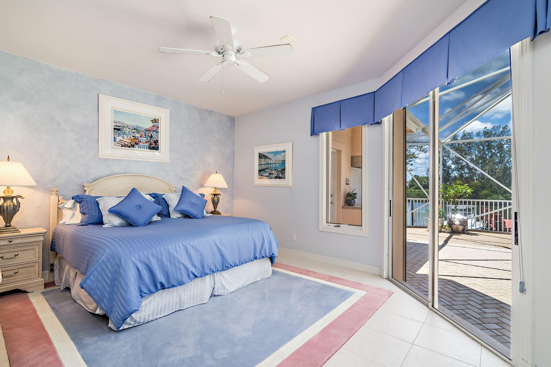 16757 Port Royal Circle Jupiter, FL 33477 - Photo 27 of 65 a bedroom with a large bed and a large window