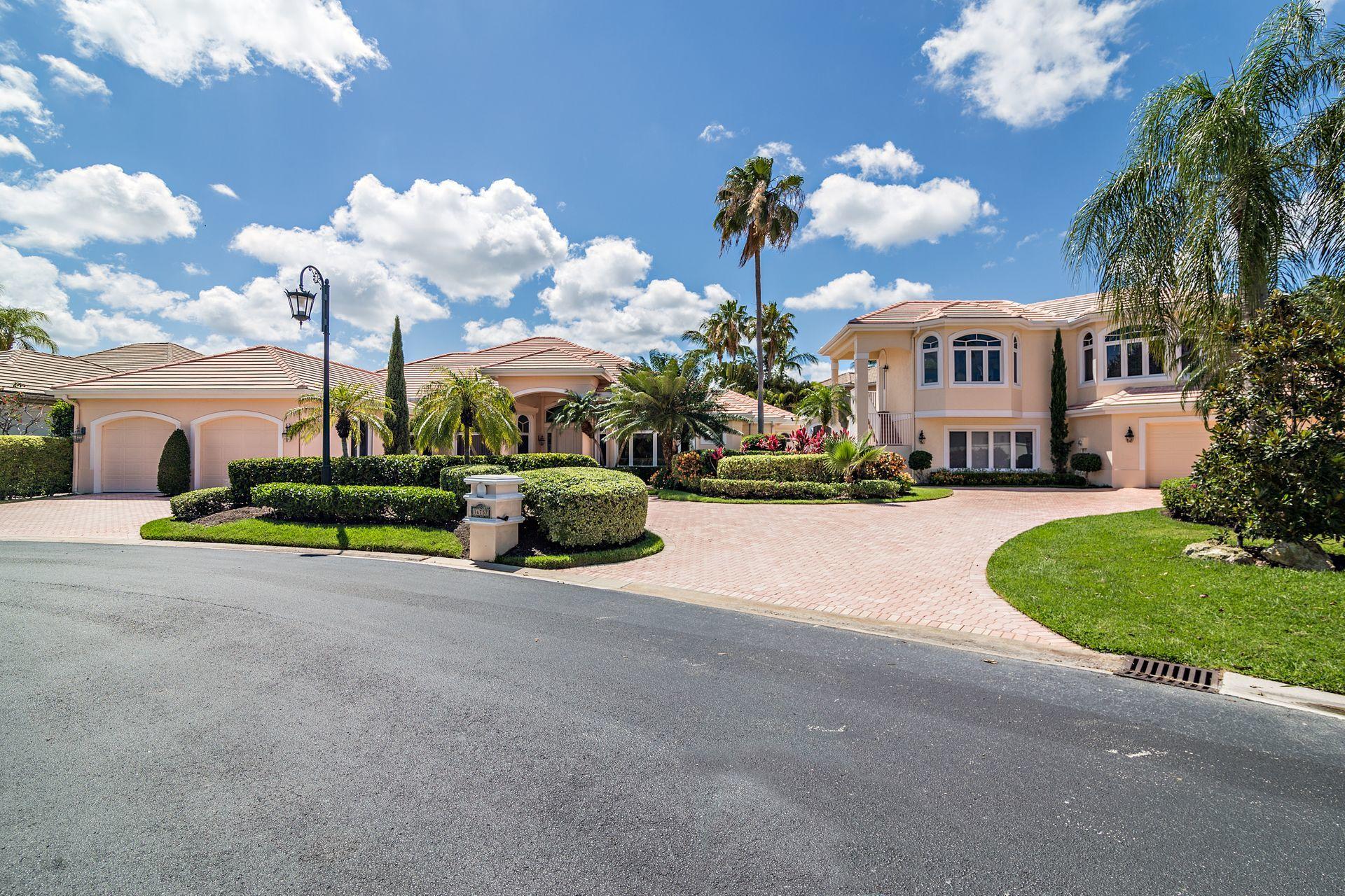 16757 Port Royal Circle Jupiter, FL 33477 - Photo 5 of 65 a view of a house with a big yard and palm trees