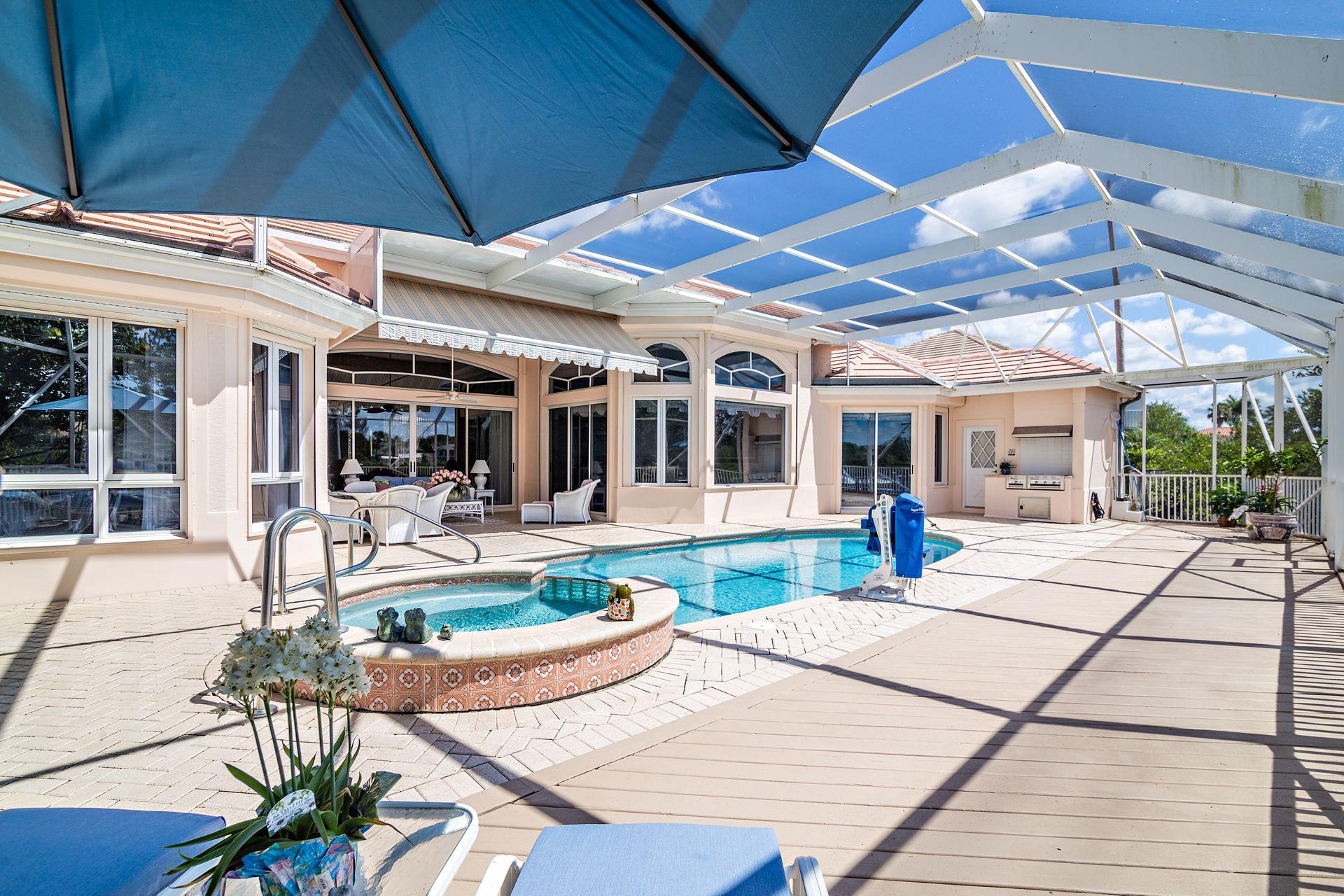 16757 Port Royal Circle Jupiter, FL 33477 - Photo 53 of 65 a view of a patio with table and chairs under an umbrella