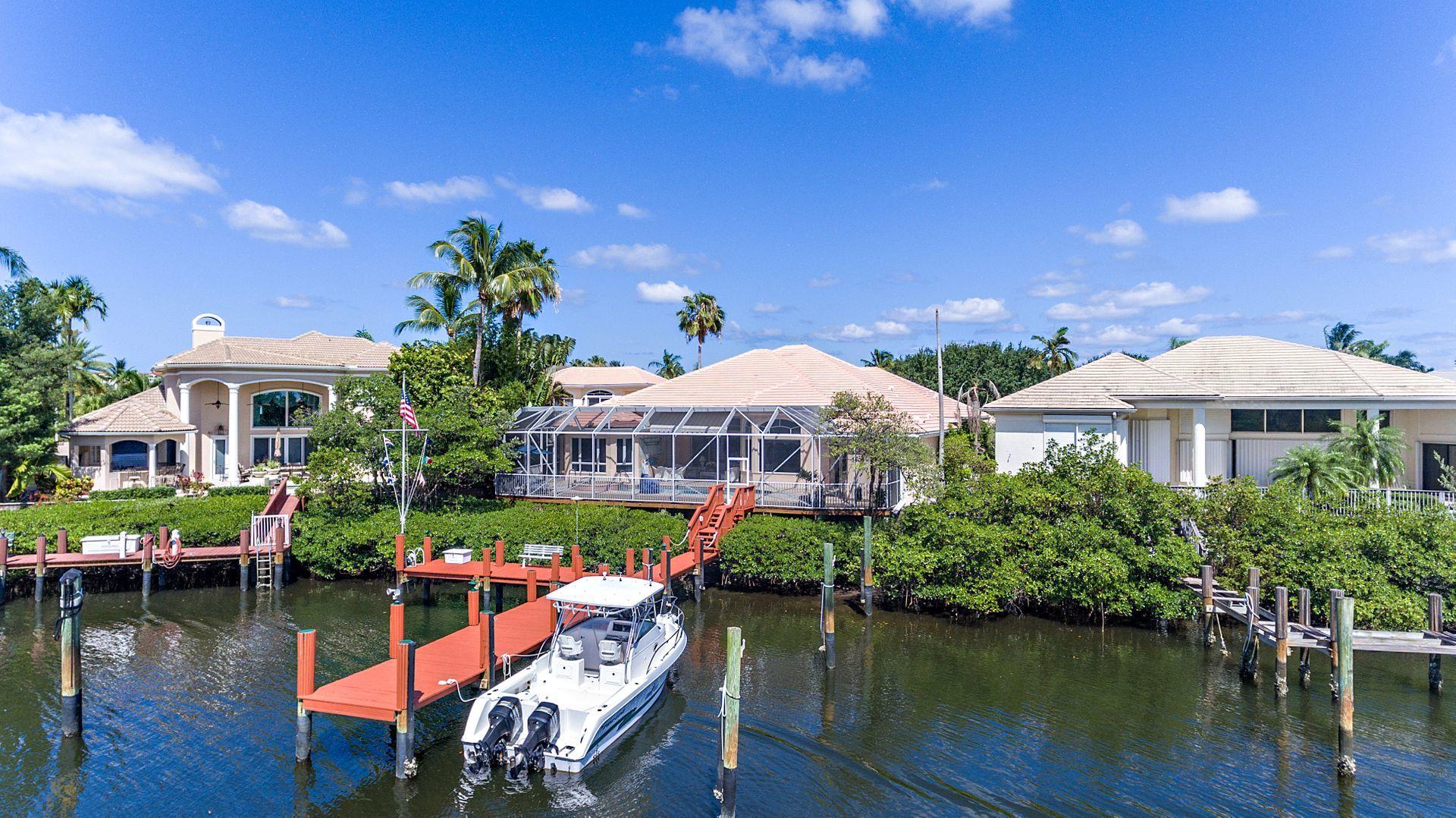 16757 Port Royal Circle Jupiter, FL 33477 - Photo 57 of 65 a front view of a house with swimming pool and outdoor seating