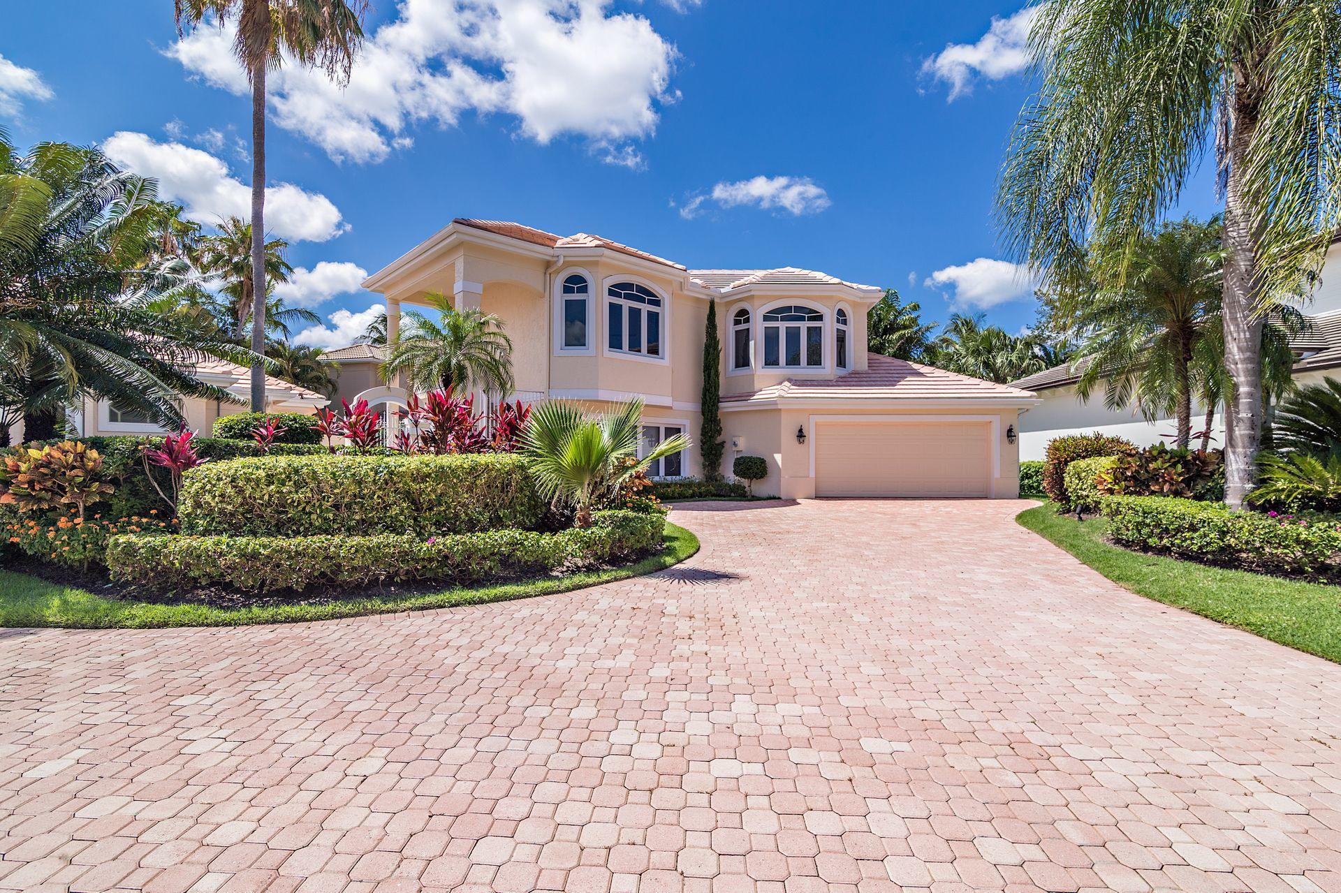 16757 Port Royal Circle Jupiter, FL 33477 - Photo 8 of 65 a front view of a house with a garden and a yard