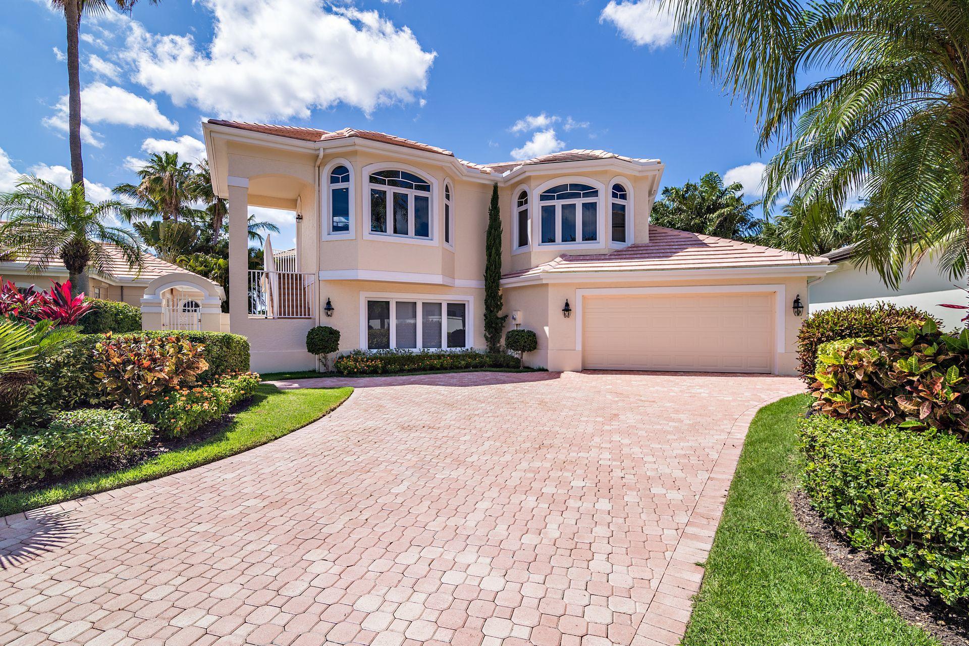 16757 Port Royal Circle Jupiter, FL 33477 - Photo 9 of 65 a front view of a house with a garden and trees
