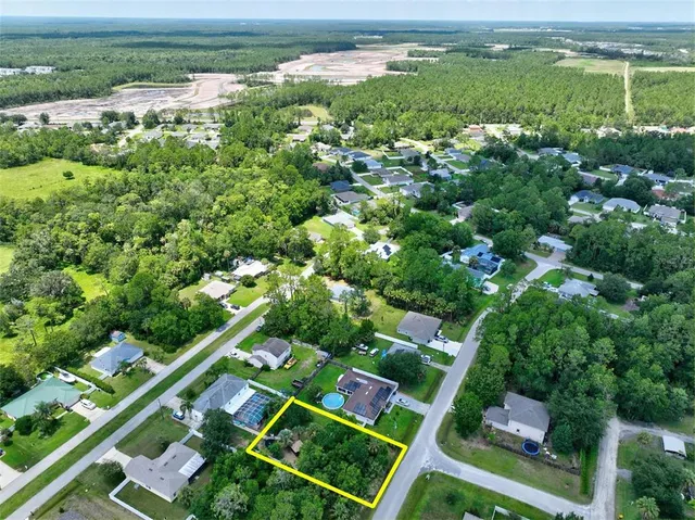 an aerial view of residential houses with outdoor space and trees