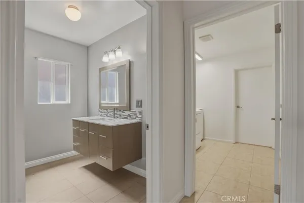 a view of a bathroom with mirror and sink