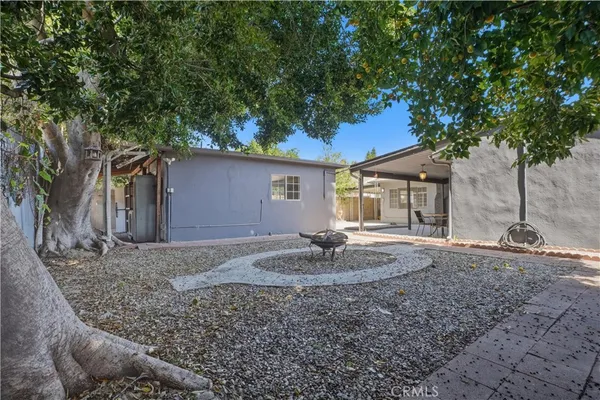 a view of a house with backyard and trees