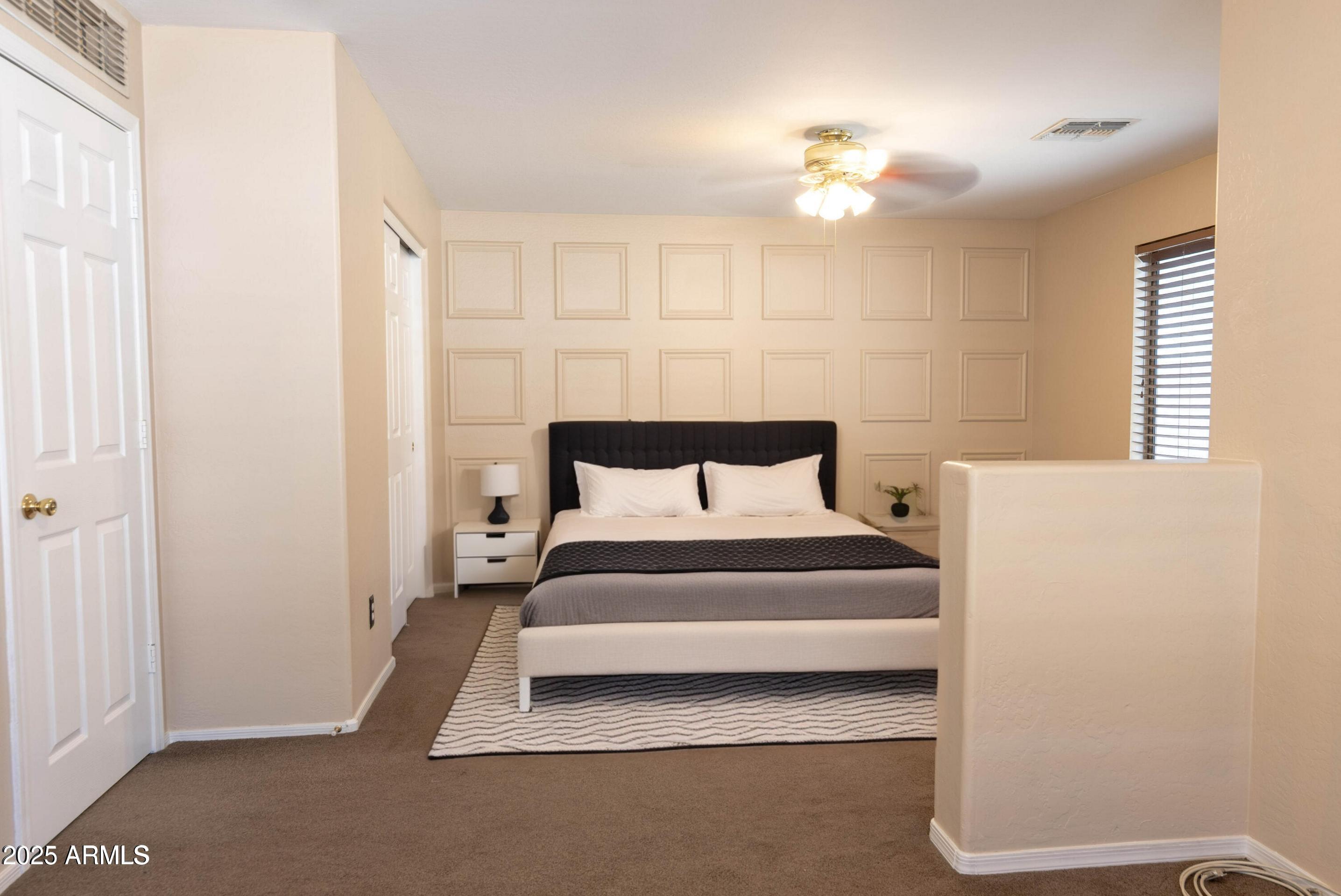 10649 West Monte Vista Road Avondale, AZ 85392 - Photo 14 of 28 a bedroom with a bed and a chandelier