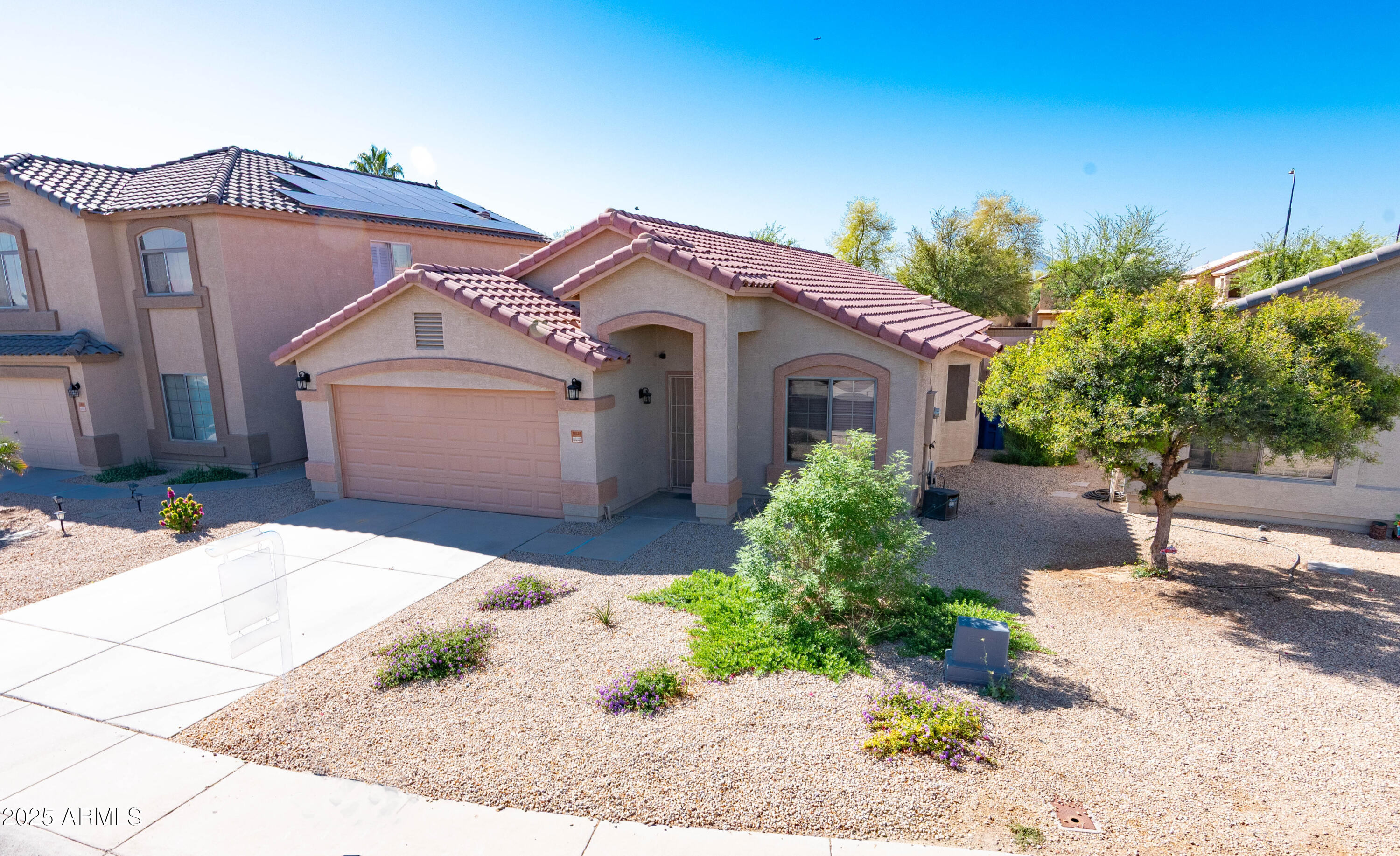 10649 West Monte Vista Road Avondale, AZ 85392 - Photo 2 of 28 a front view of a house with a garden