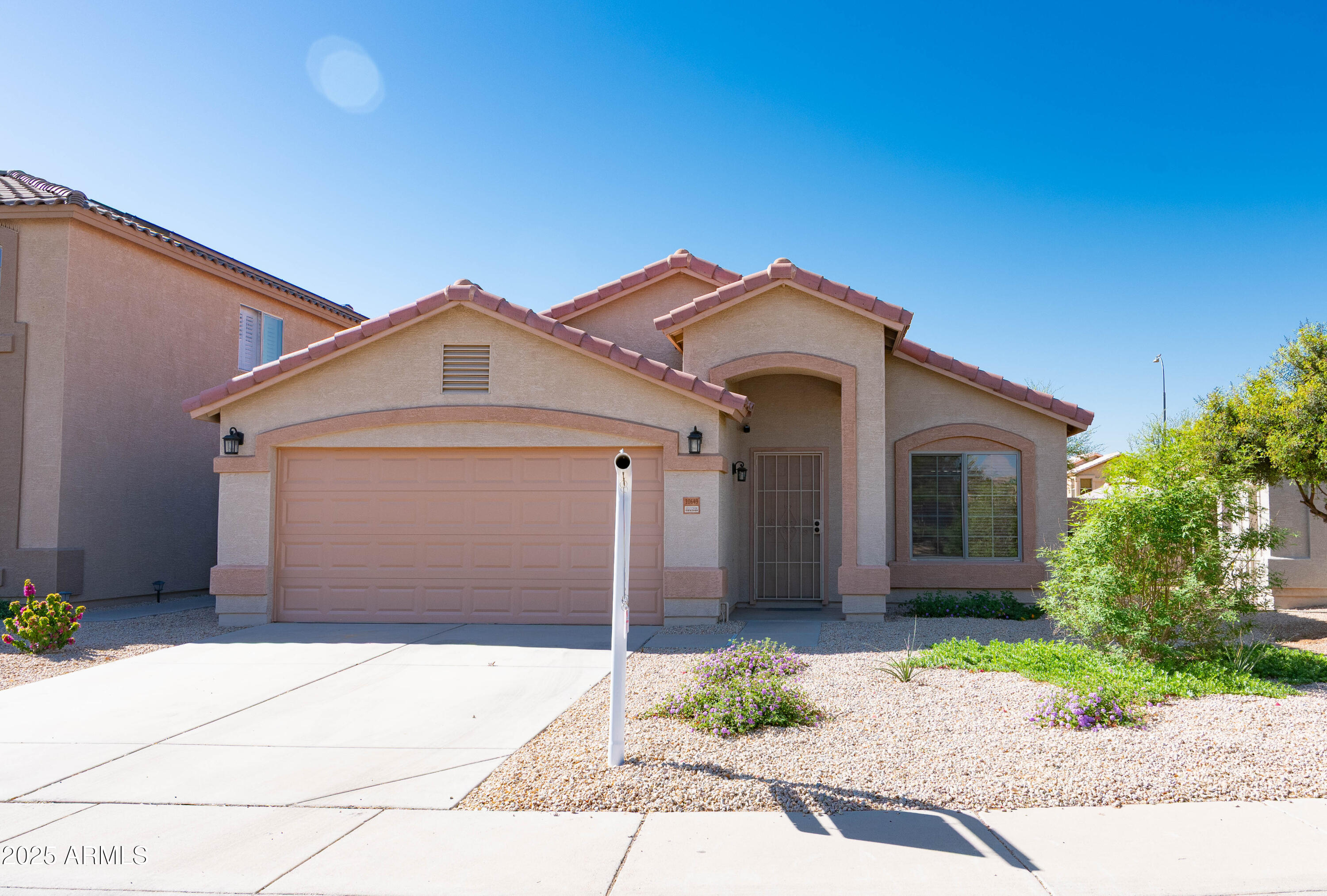 10649 West Monte Vista Road Avondale, AZ 85392 - Photo 28 of 28 a front view of a house with a garden and entryway