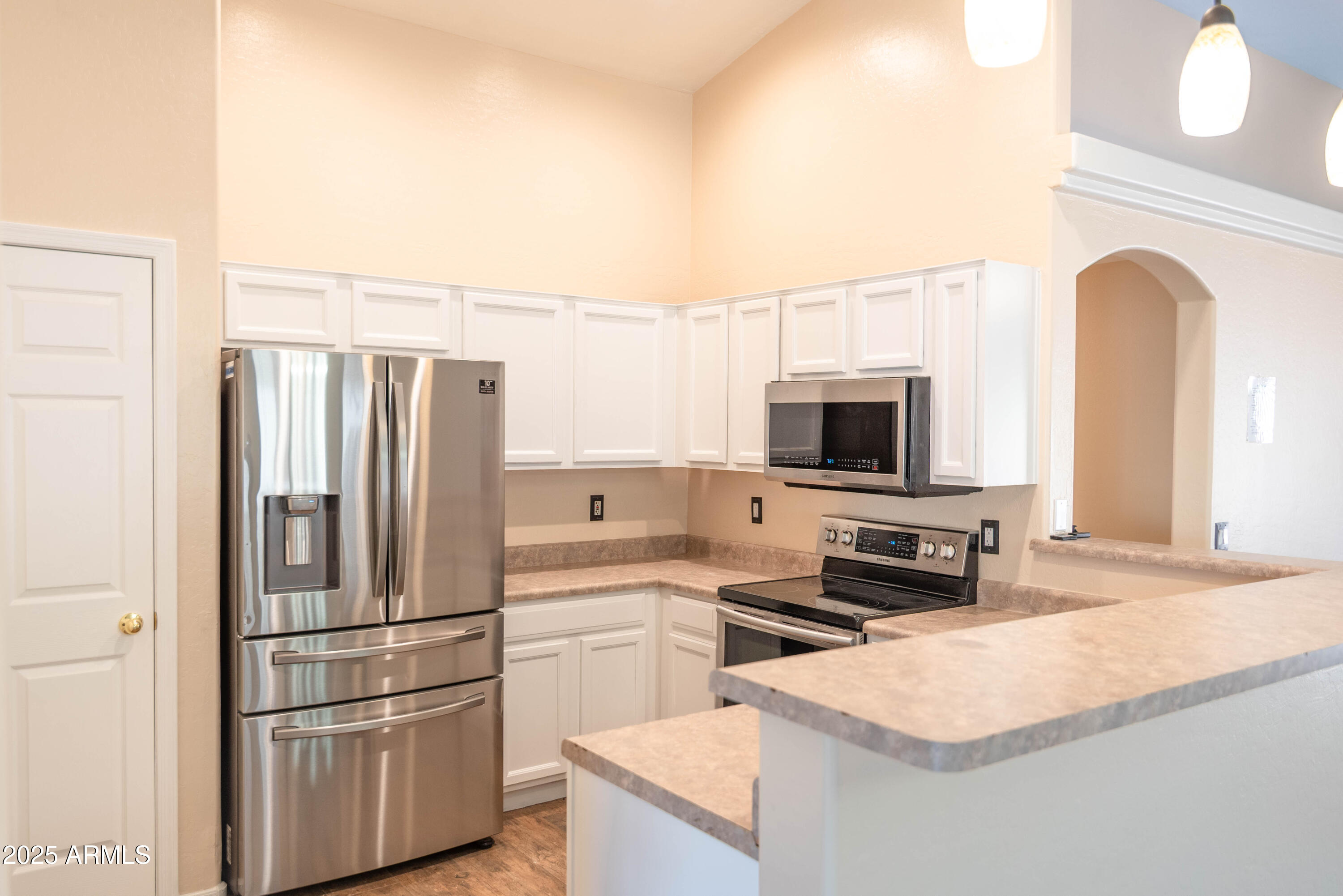 10649 West Monte Vista Road Avondale, AZ 85392 - Photo 5 of 28 a kitchen with stainless steel appliances granite countertop a refrigerator a stove and a sink