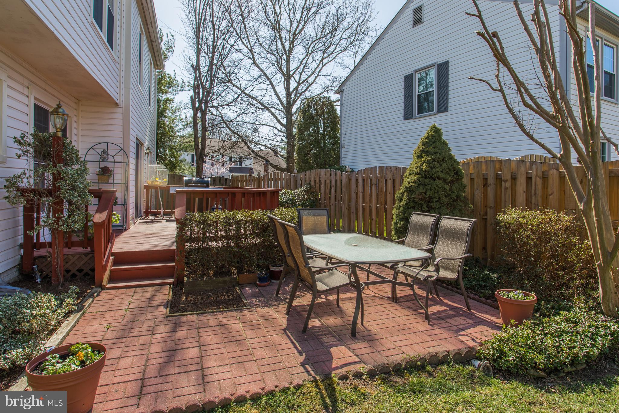 13345 Point Rider Lane Herndon, VA 20171 - Photo 28 of 30 a view of a patio with table and chairs and potted plants with wooden floor and fence