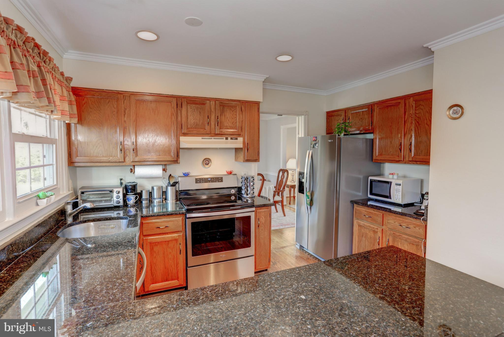 13345 Point Rider Lane Herndon, VA 20171 - Photo 4 of 30 a kitchen with stainless steel appliances granite countertop a stove a sink dishwasher a refrigerator and a stove with wooden floor