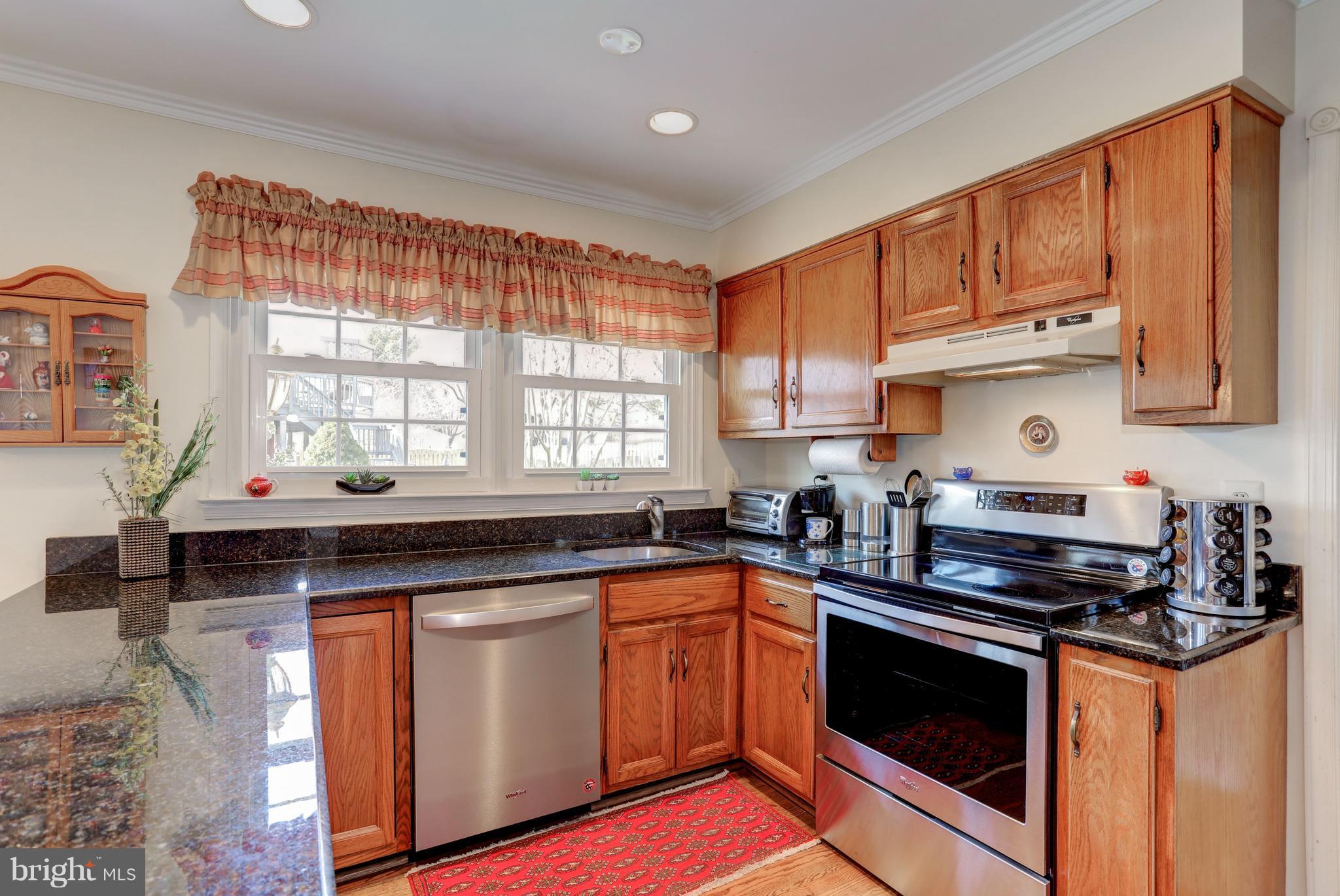 13345 Point Rider Lane Herndon, VA 20171 - Photo 5 of 30 a kitchen with stainless steel appliances granite countertop a stove a sink and a microwave