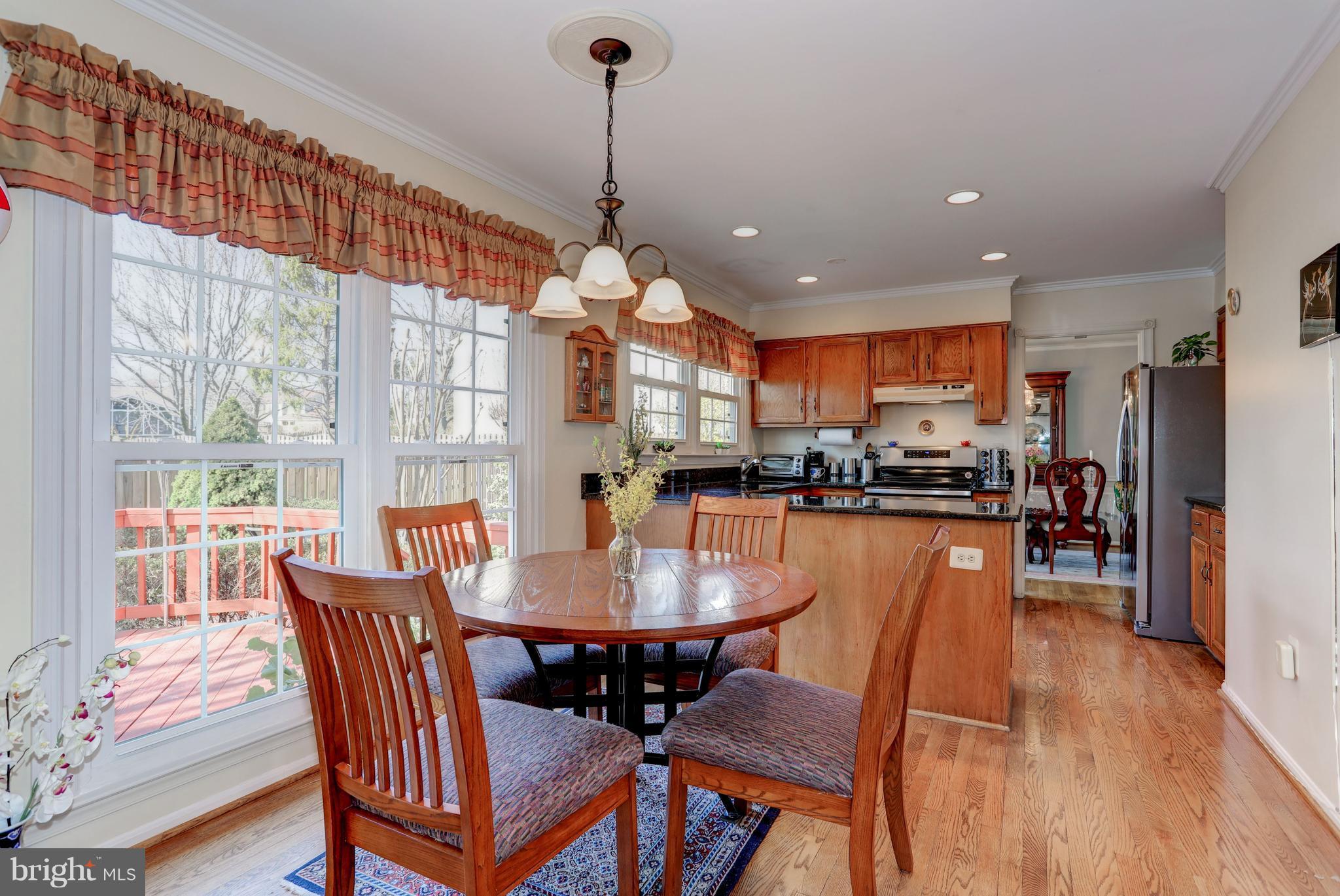 13345 Point Rider Lane Herndon, VA 20171 - Photo 7 of 30 a view of a dining room and livingroom with furniture wooden floor a chandelier