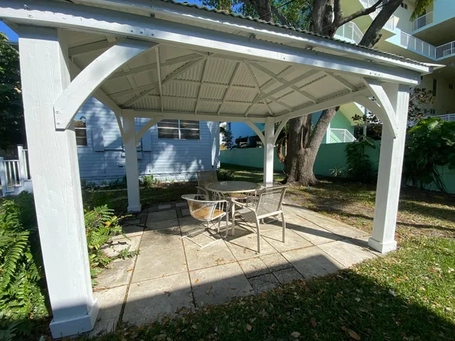 a view of patio with table and chairs under an umbrella